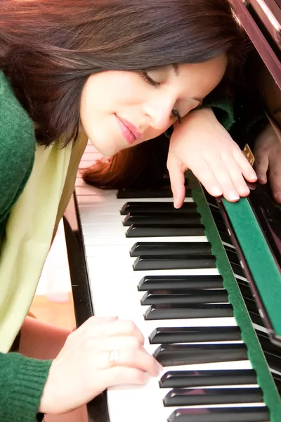 Portrait of a beautiful brunette and her piano — Stock Photo, Image