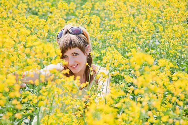 Meisje in een veld van koolzaad — Stockfoto
