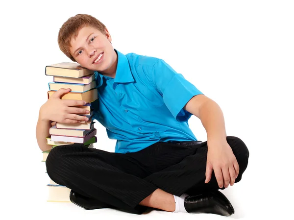 Yakışıklı genç bir öğrenci ile yığın kitap — Stok fotoğraf
