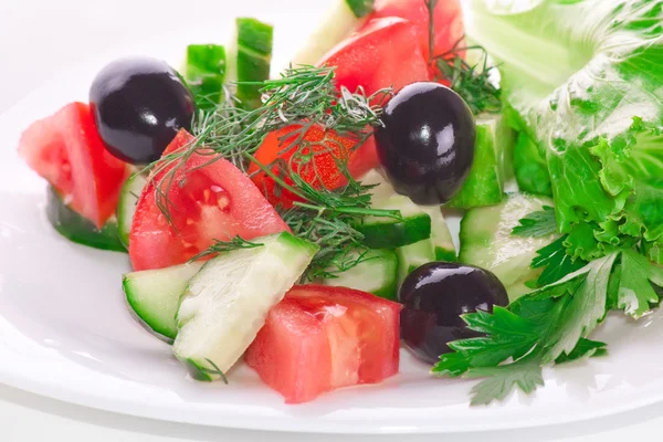 Salada grega de tomates, azeitonas e um pepino com verdes — Fotografia de Stock