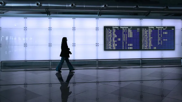 Kvinne som går på flyplassen – stockfoto