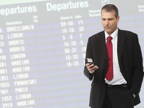 Empresário que liga o telefone móvel no aeroporto — Fotografia de Stock