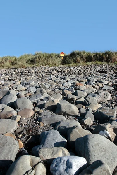 Koło ratunkowe na kamienistej plaży — Zdjęcie stockowe