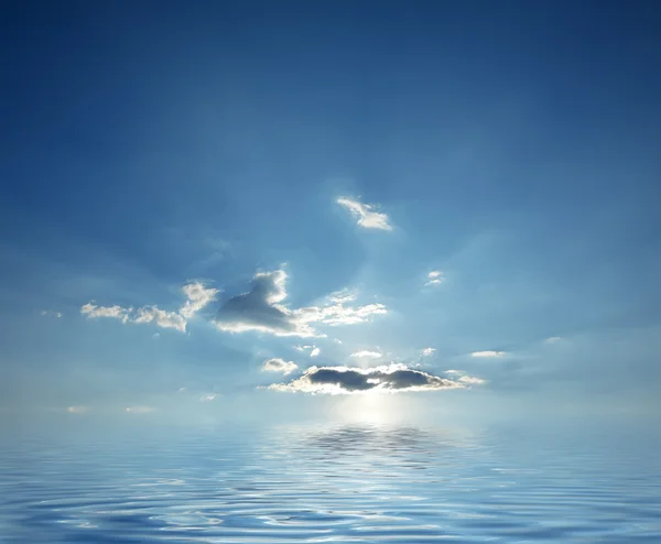 Μπλε ουρανό θολό Ανατολή του ηλίου πάνω από τον ωκεανό ήρεμο νερό — Φωτογραφία Αρχείου