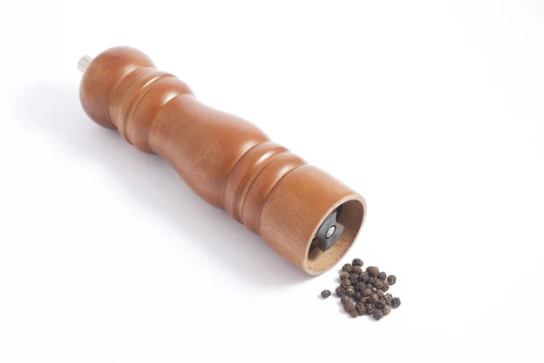 Houten peper grinder en peper korrels — Stockfoto