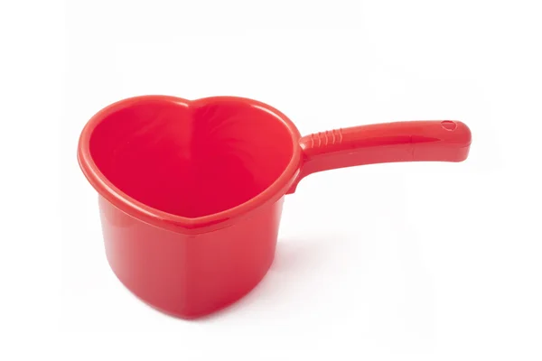 Red plastic ladle similar to a heart — Stock Photo, Image
