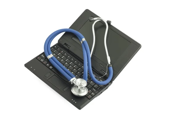 Netbook preto e estetoscópio médico em branco — Fotografia de Stock