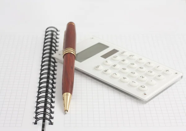 A spirál Jegyzettömb a toll és a fehér kalkulátor — Stock Fotó