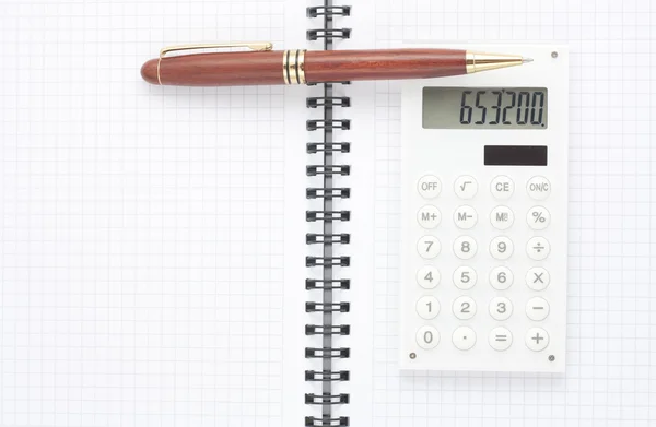 Pióra i biała kalkulator na notatnik spirala, widok z góry — Zdjęcie stockowe