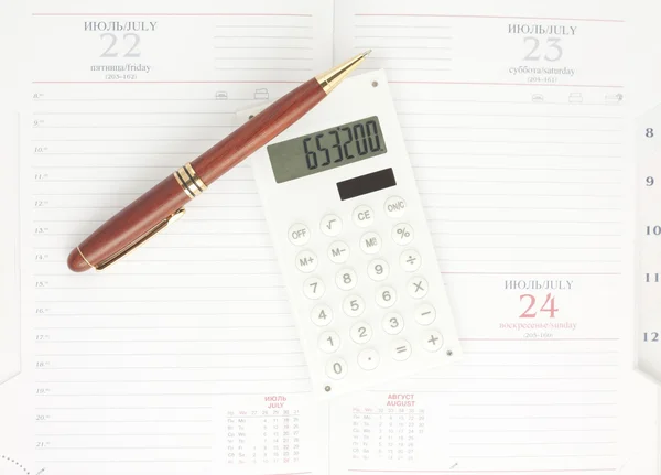 Ручка и белый калькулятор на органайзере, вид сверху — стоковое фото