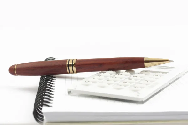 A spirál Jegyzettömb a toll és a fehér kalkulátor — Stock Fotó