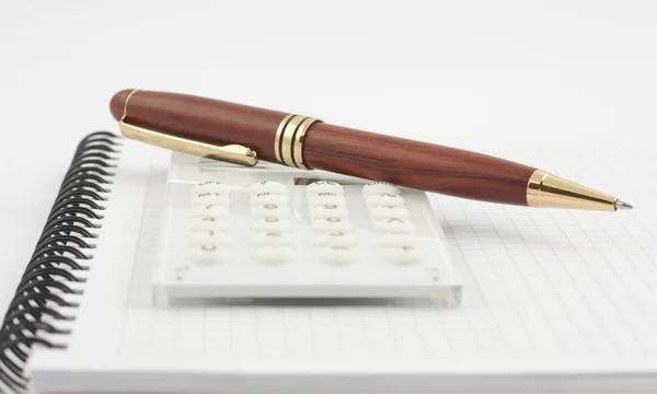 Pen en witte calculator op de spiraal Kladblok — Stockfoto
