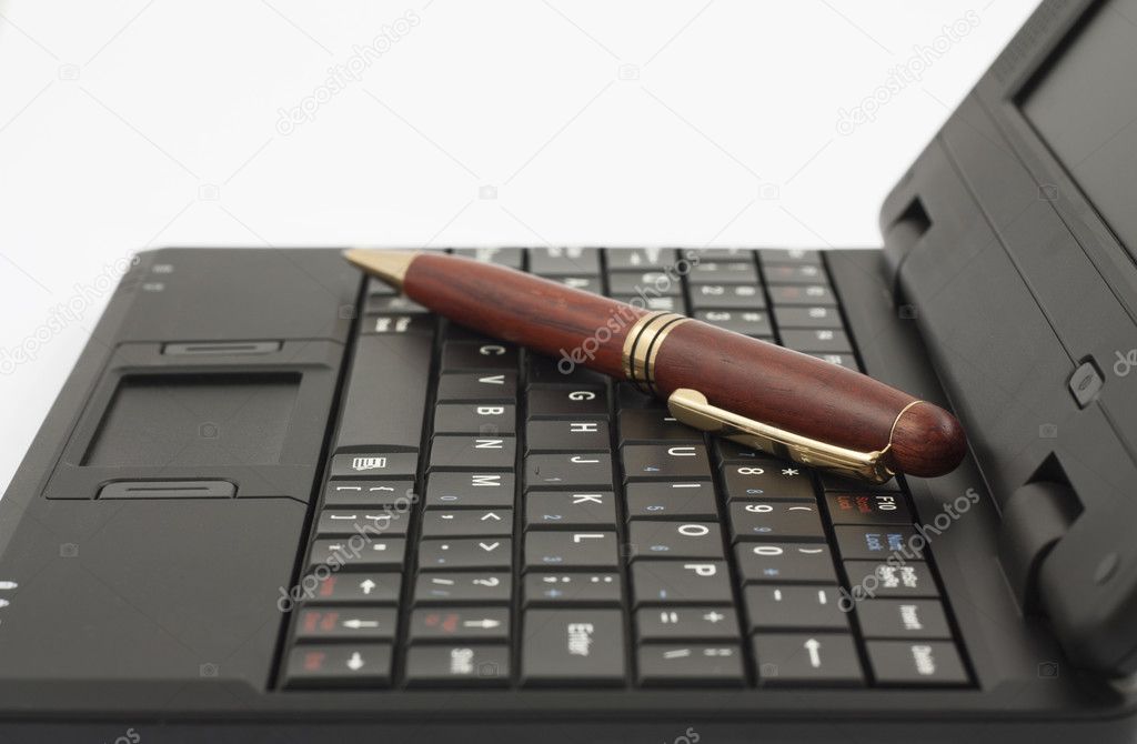 The wooden pen on notebook keyboard