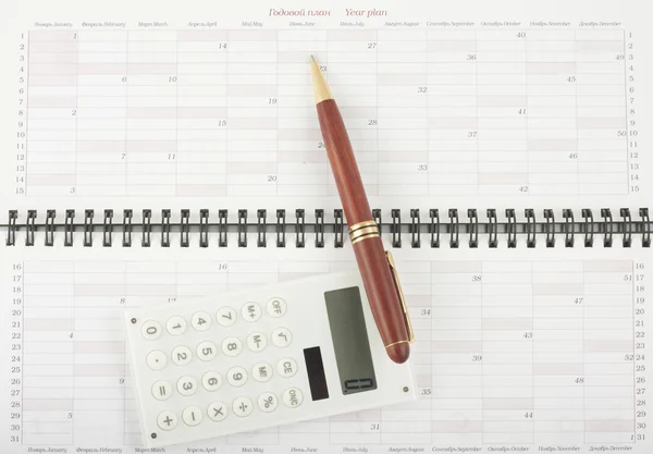 Ручка и калькулятор на план открытого года — стоковое фото