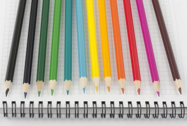 उघडलेल्या आवर्त नोटबुकवर बहु रंगीबेरंगी पेन्सिल — स्टॉक फोटो, इमेज
