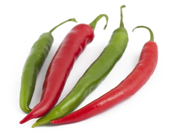 Dos chiles verdes y dos chiles rojos sobre blanco — Foto de Stock