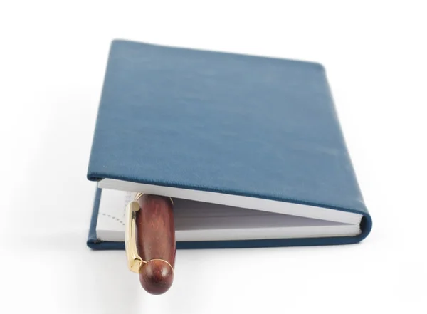 Ручка в закрытом голубом блокноте — стоковое фото