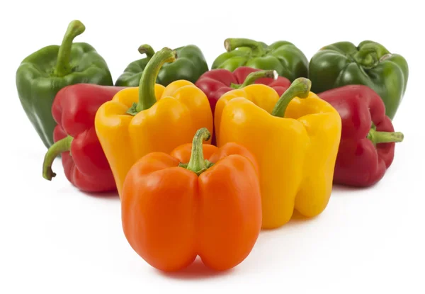 Green, yellow, orange and red peppers on white background — Stock Photo, Image