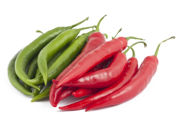 Många röd och grön chilipeppar på vit — Stockfoto