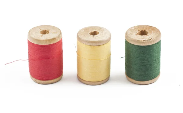 Three wooden multicolored thread coils on white — Stock Photo, Image