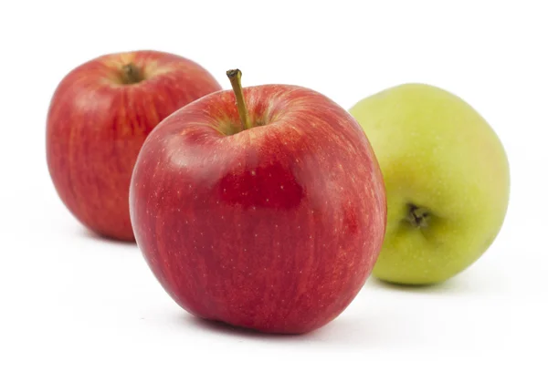 Два красных и одно зеленое яблоко на белом — стоковое фото