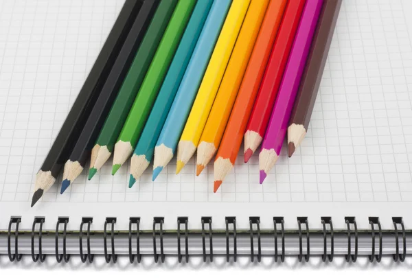 Crayons multicolores sur carnet spirale — Photo