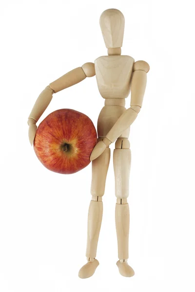 Wooden mannequin holds red apple — Stock Photo, Image