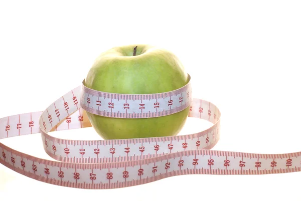 Una manzana verde y una cinta métrica —  Fotos de Stock