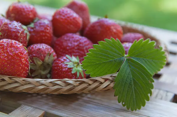 Strawberry in a wattled basket on a table — Stock Photo, Image