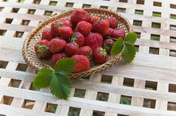 Strawberry in a wattled basket on a table — Stock Photo, Image