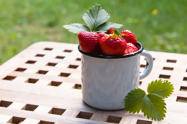 Strawberry in a mug on a table — Stock Photo, Image
