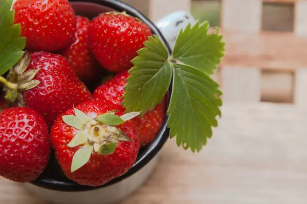 Strawberry in a mug on a table — Stock Photo, Image