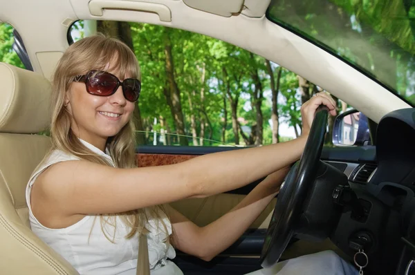 stock image The young woman sits at the wheel the car