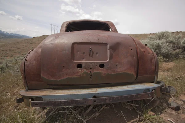 Старая брошенная машина с дырками от пуль — стоковое фото