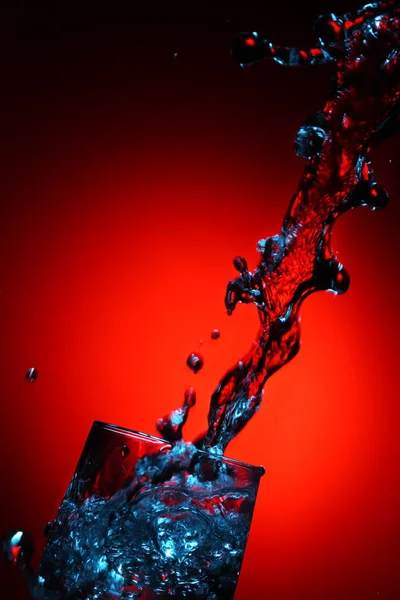 Vatten stakanina röd bakgrund — Stockfoto