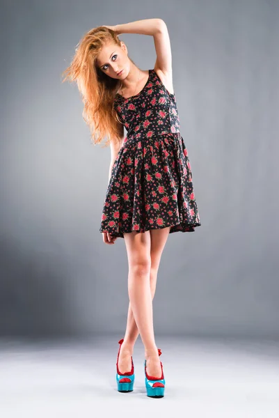 Vacker rödhårig flicka på grå bakgrund — Stockfoto