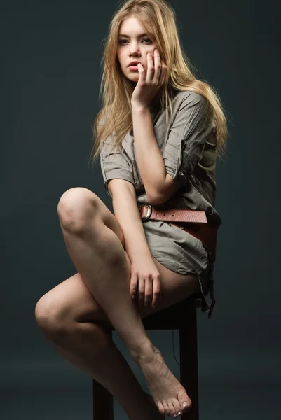 Verleidelijke portret van jonge vrouw zittend op stoel — Stockfoto