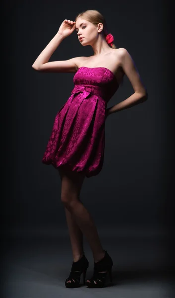Krásná mladá žena nosí růžové šaty a vysoké podpatky — Stock fotografie