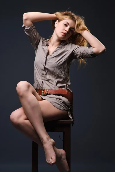 Attractive blond girl sits on chair — Stock Photo, Image