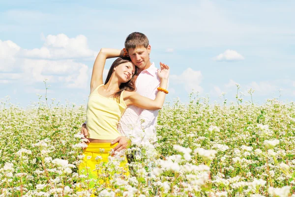 Schönes junges Paar inmitten der Blumen — Stockfoto