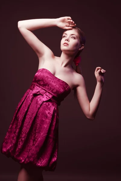 Attraktiv ung kvinna som bär på rosa klänning — Stockfoto