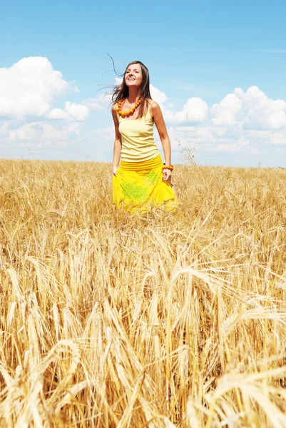 Hermosa joven jugando en un campo de trigo — Foto de Stock