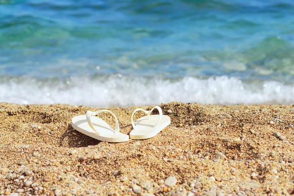 stock image Sand blue sea and slippers