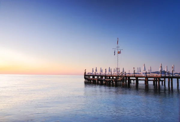 Pier lighted by sunrise glowing — Stock Photo, Image