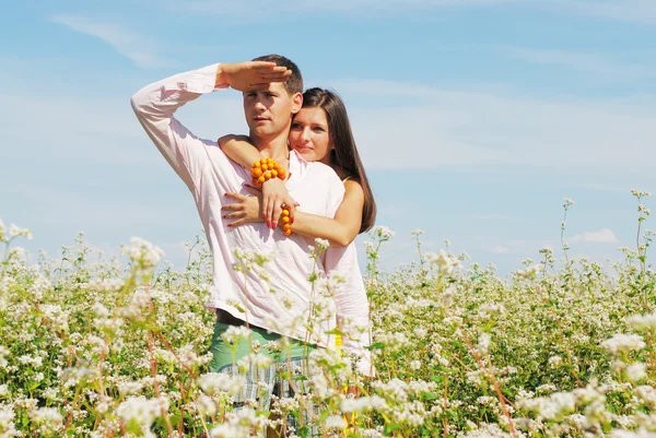 Νεαρό ζευγάρι στο πεδίο των λουλουδιών — Φωτογραφία Αρχείου