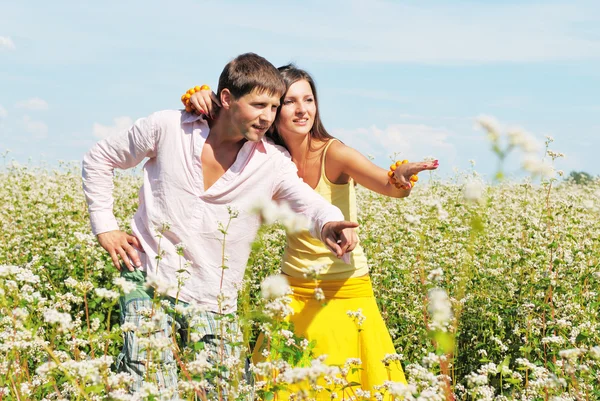 Casal jovem em campo de flores — Fotografia de Stock
