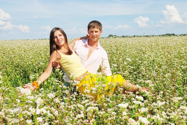 Casal jovem em campo de flores — Fotografia de Stock