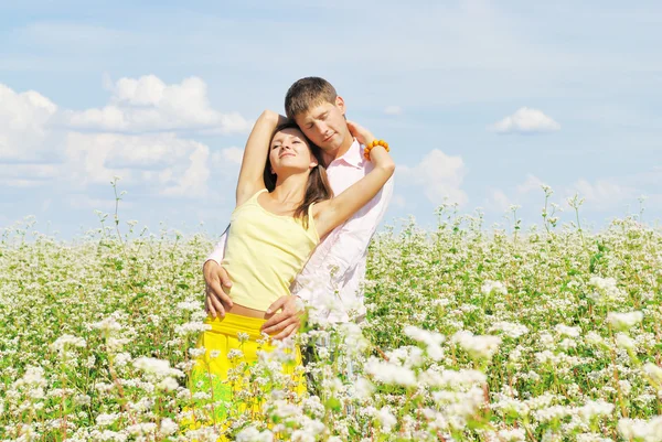 Νεαρό ζευγάρι στο πεδίο των λουλουδιών — Φωτογραφία Αρχείου