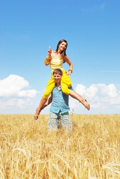 Jovem casal jogando no campo de trigo — Fotografia de Stock