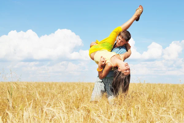 Young couple playing on wheat field — Stock Photo, Image